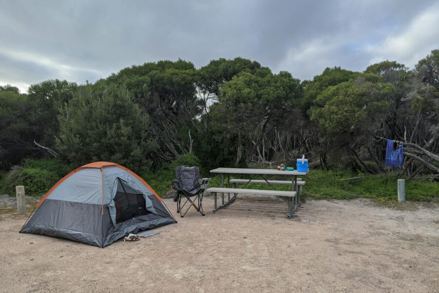Small tent set up next to a picnic table.