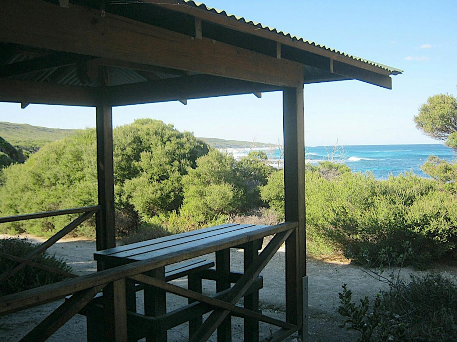 Sheltered picnic table and seat with a view of the ocean.